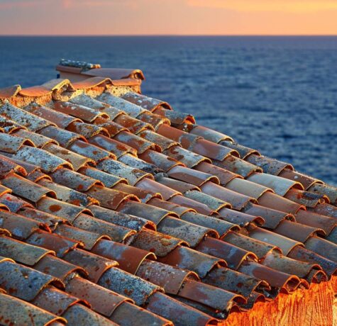 Toit traditionnel en tuiles provençales orangées à Saint-Tropez avec la mer Méditerranée en arrière-plan